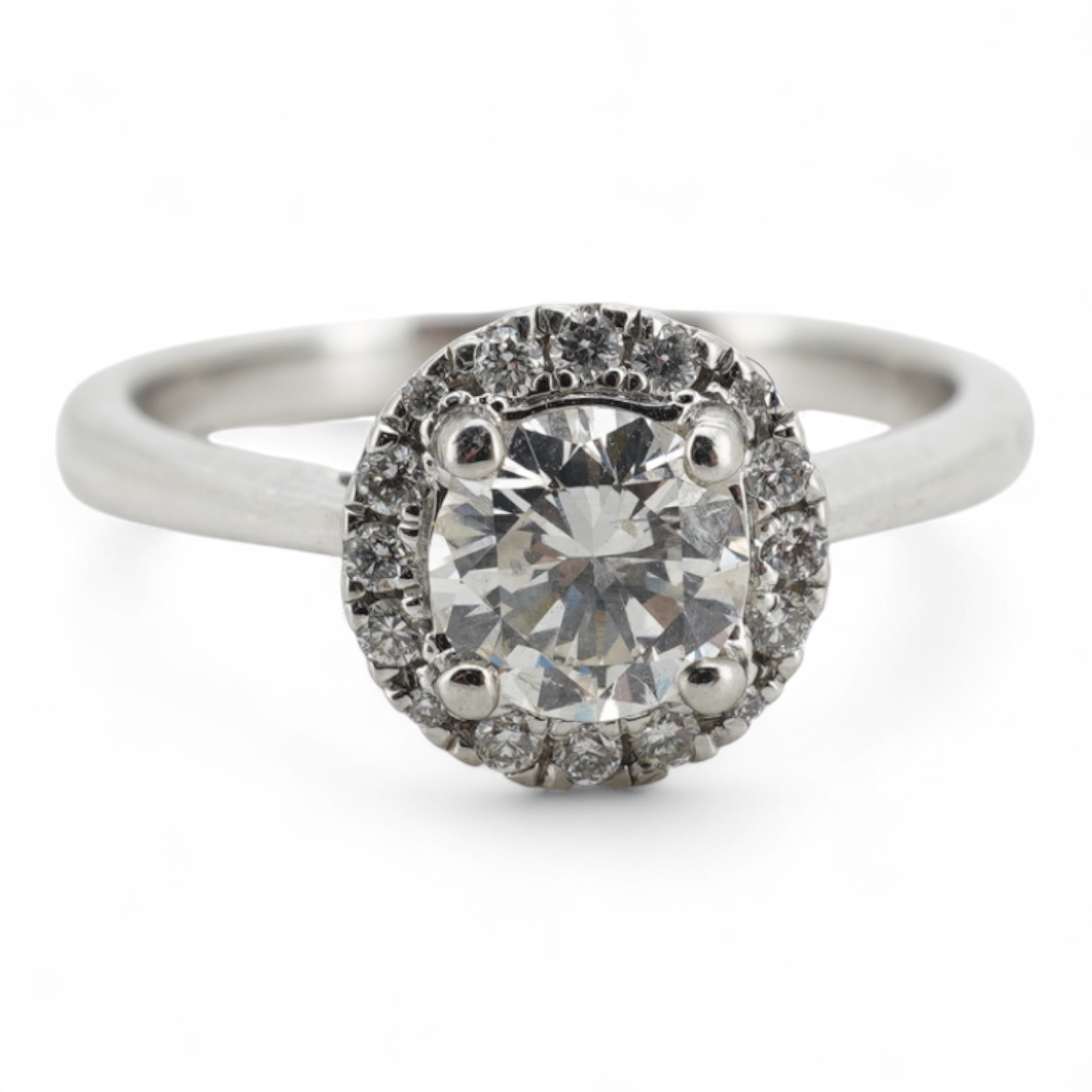 A diamond cluster ring, claw-set with a brilliant-cut diamond weighing approximately 0.70 carats, within a border of smaller brilliant-cut diamonds totalling approximately 0.10 carats, mounted in platinum, size M, Britis